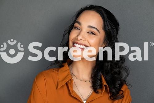 Close Up Face Of Young Woman With Beautiful Smile Isolated On Grey Wall With Copy Space Successful Multiethnic Girl Latin Woman Looking At Camera Against Gray Wall With A Big Whitening Teeth Smile