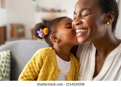 Close Up Of Beautiful Daughter Kissing Mother On Cheek At Home African Little Girl Giving Kiss To Happy Mother Lovely Black Female Child Kissing Cheerful And Proud Woman On Cheek For Mothers Day