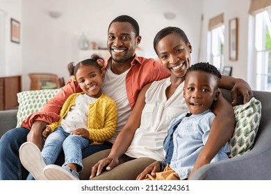 Portrait Of Happy Mature Couple With Son And Daughter Relaxing On Sofa At Home Middle Aged Black Woman With Husband And Children Smiling And Looking At Camera Beautiful Mid African American Family