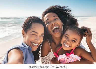 Portrait Of Smiling Young African American Woman With Child Taking Selfie At Beach With Her Best Friend Cheerful Multiethnic Gay Couple Enjoying At Beach With Daughter During Summer Holiday 