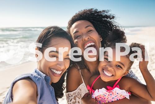 Portrait Of Smiling Young African American Woman With Child Taking Selfie At Beach With Her Best Friend Cheerful Multiethnic Gay Couple Enjoying At Beach With Daughter During Summer Holiday 