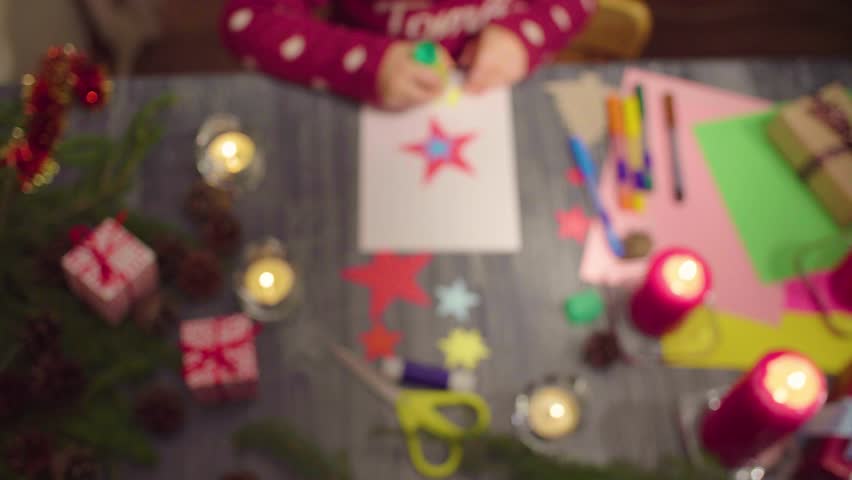 Crane Shot Top View Little Girl Glues New Year Card Clip Out Of Focus At The Beggining Then Focused On The Postcard French Text On A Sweater   Falls