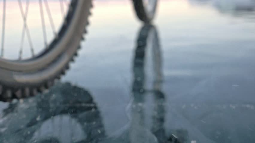 View Of The Tire Shooting 180fps Woman Is Riding Bicycle On The Ice Ice Of The Frozen Lake Baikal The Tires On The Bicycle Are Covered With Special Spikes The Traveler Is Ride A Cycle