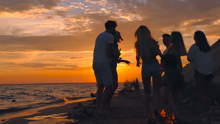 Friends Having Fun On The Beach Party During The Sunset Time