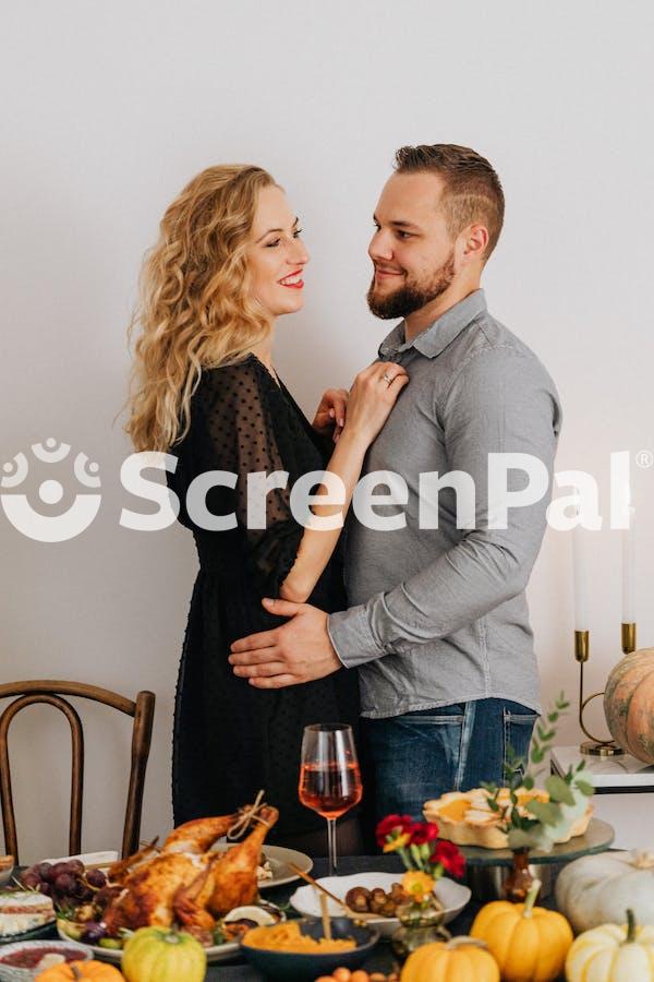 Couple Hugging Near Table At Thanksgiving Dinner