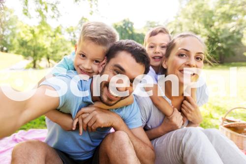 Family Leisure And Technology Concept   Happy Mother Father And Two Little Sons Having Picnic And Taking Selfie At Summer Park