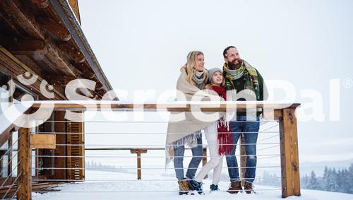 Family With Small Daughter On Terrace Outdoors Holiday In Winter Nature