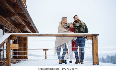 Family With Small Daughter On Terrace Outdoors Holiday In Winter Nature