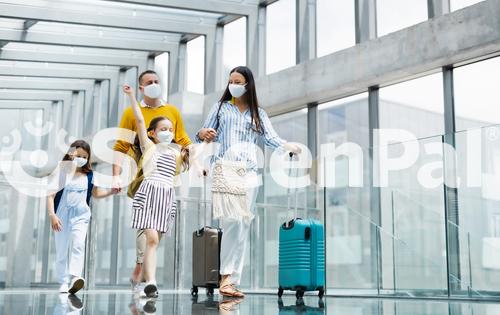 Family With Two Children Going On Holiday Wearing Face Masks At The Airport