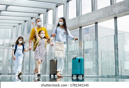 Family With Two Children Going On Holiday Wearing Face Masks At The Airport