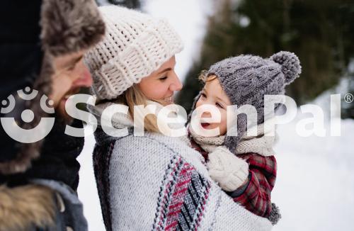 Father And Mother With Small Child In Winter Nature Standing In The Snow