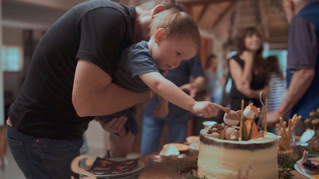 The Birthday Boy Touching The Animal Image Decoration On His Cake