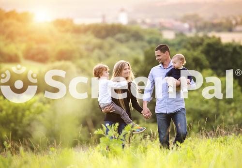 Happy Young Family Spending Time Together Outside In Green Nature