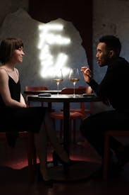 Man And Woman Sitting On Chair In Front Of Table