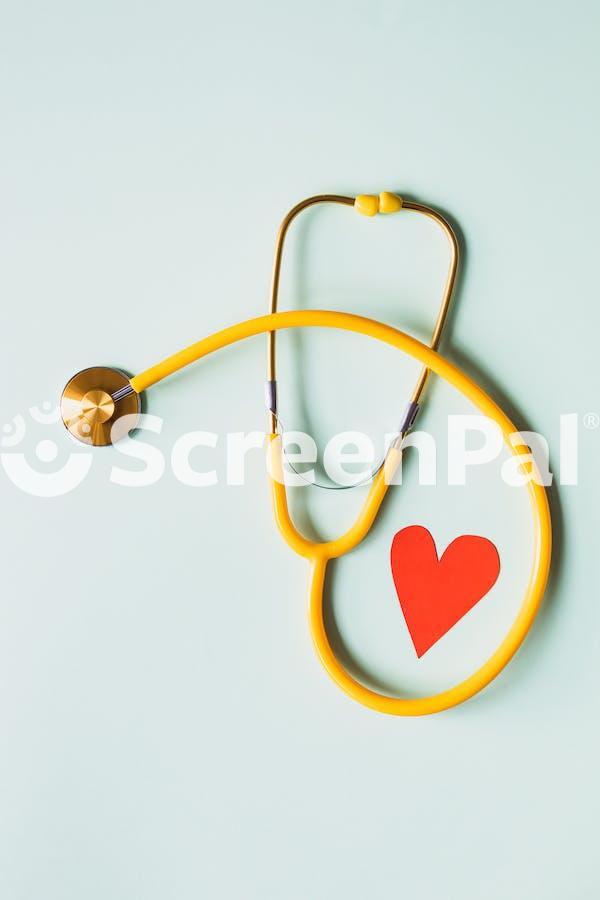 Medical Stethoscope With Red Paper Heart On White Surface