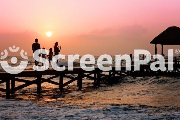 People Standing On Dock During Sunrise