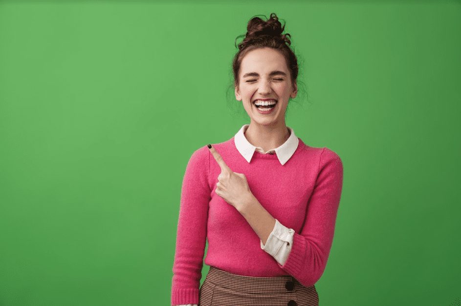 student in front of a green screen