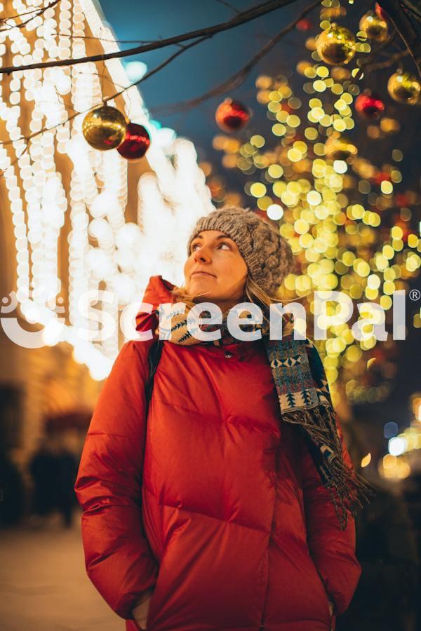 Smiling Woman In City Decorated For Christmas