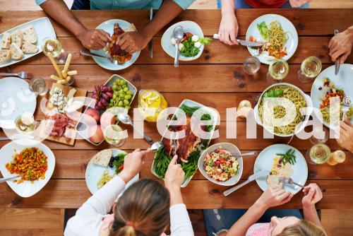 Thanksgiving Day Eating And Leisure Concept   Group Of People Having Roast Chicken Or Turkey For Dinner At Table With Food