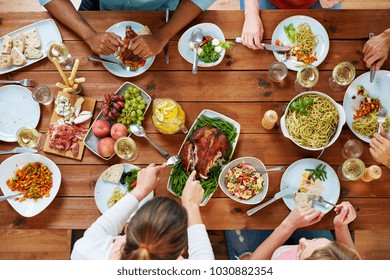 Thanksgiving Day Eating And Leisure Concept   Group Of People Having Roast Chicken Or Turkey For Dinner At Table With Food