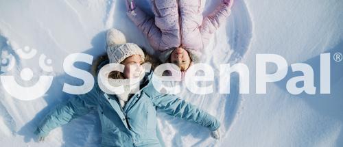 Top View Portrait Of Cheerful Mother With Small Daughter Lying In Snow In Winter Nature