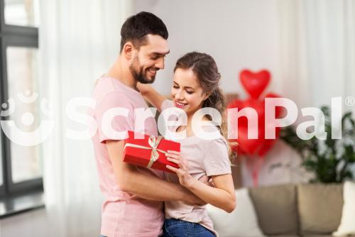 Valentines Day Relationships And People Concept   Happy Couple With Gift Box Hugging At Home