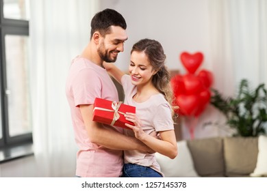 Valentines Day Relationships And People Concept   Happy Couple With Gift Box Hugging At Home