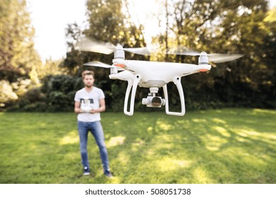 Young Hipster Man With Flying Drone Sunny Green Nature